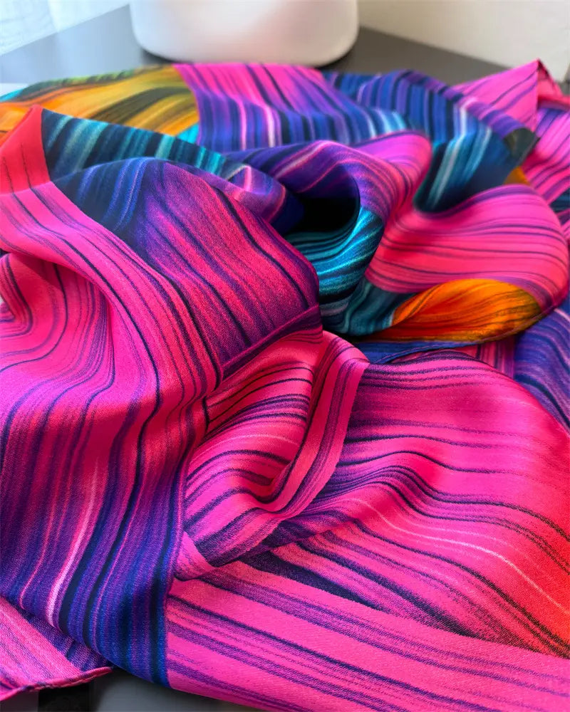 Ein lebendiger Seidenschal für Damen mit kräftigen diagonalen Streifen in Pink, Lila, Blau und Orange, entworfen als Colorblock-Frühlingsschal-Wickel.