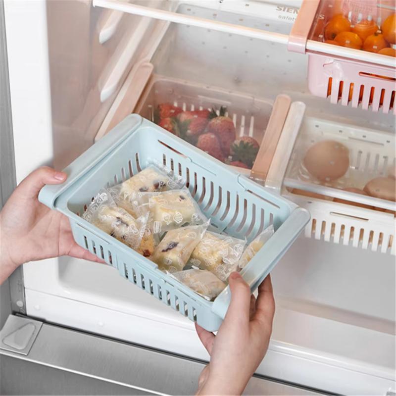 Light blue plastic fridge organizer basket made of food-grade polypropylene with slotted sides and a handle suitable for use as a sink drain rack or adjustable kitchen shelf.