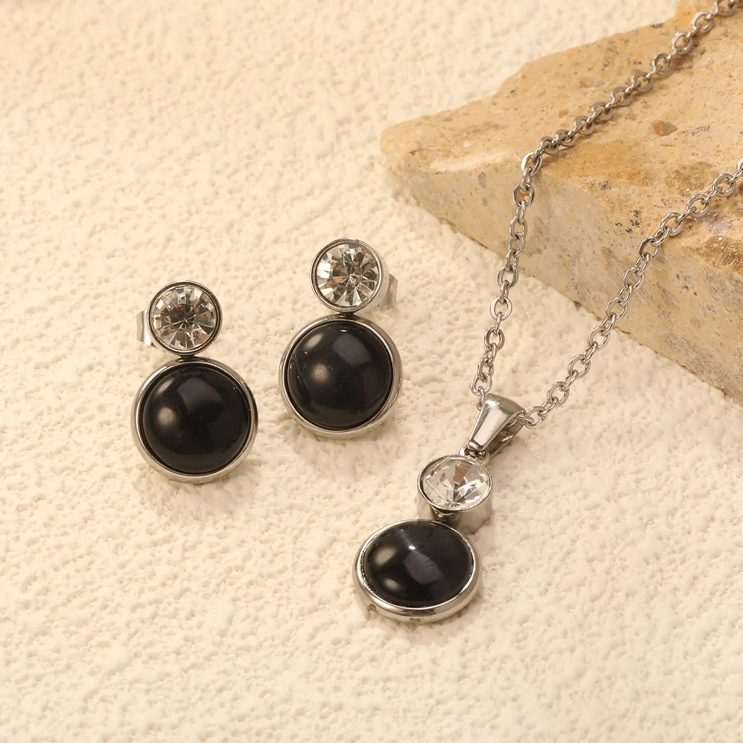 Silver-toned stainless steel black opal necklace and earring set featuring a black onyx-like stone with clear crystal accent.