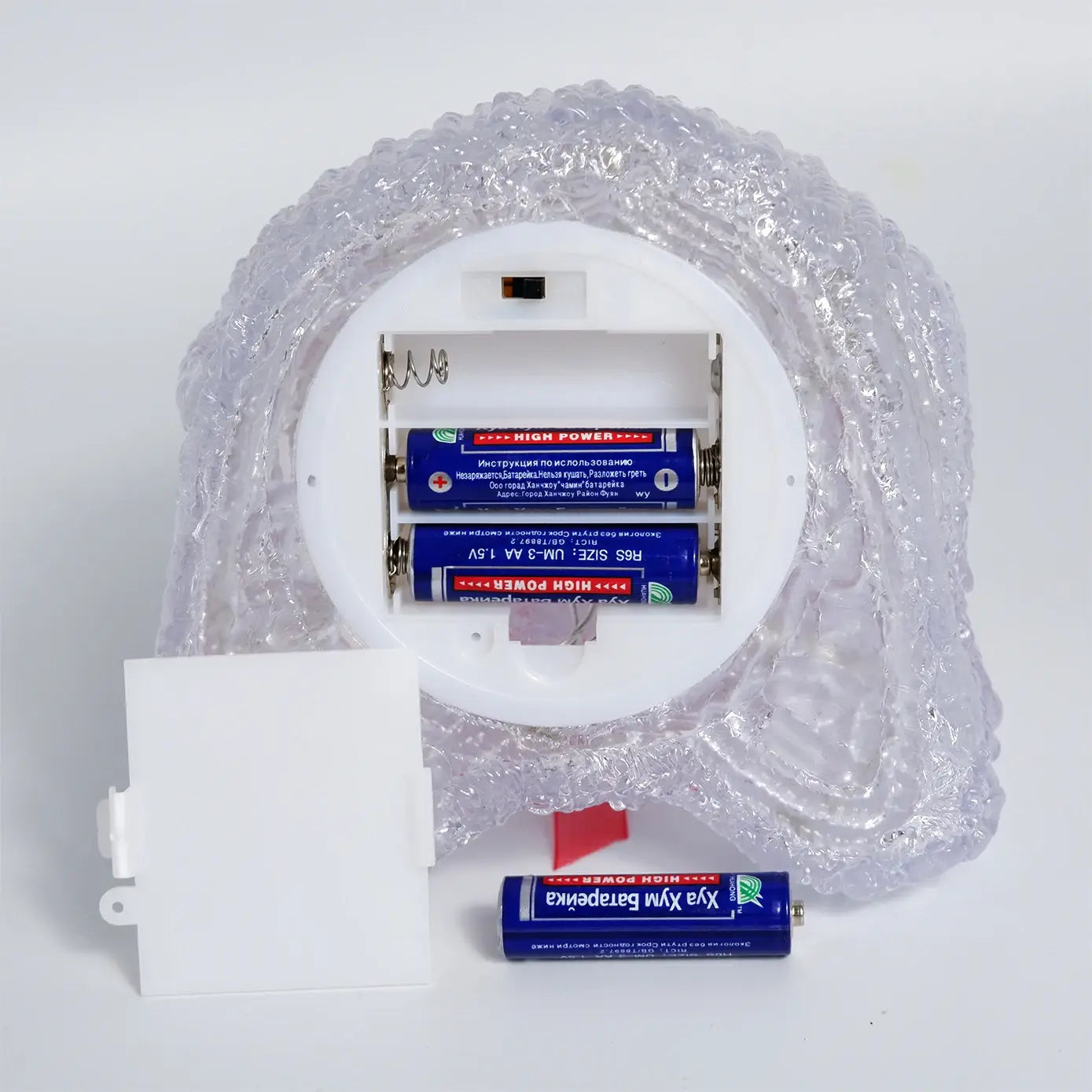 LED-Rentier-Weihnachtsornamentlicht mit klar strukturiertem Kunststoff-Licht in Form eines Schädels, mit weißem Batteriefach zur Aufnahme von zwei AA-Batterien, von der Rückseite aus gezeigt.