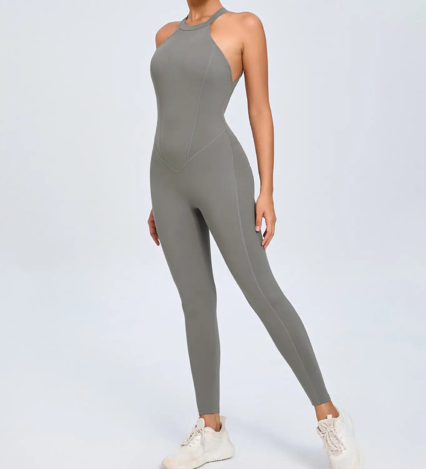 A sleek gray one-piece athletic jumpsuit with a high neckline and cut-out shoulders designed for workout use.