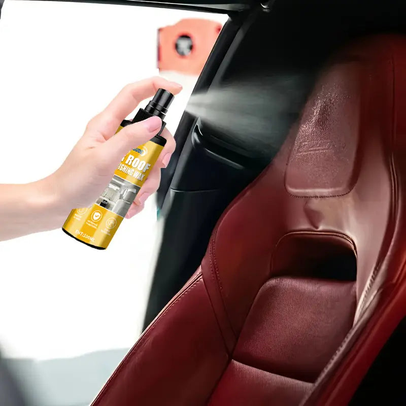 黒いノズルの付いた黄色のカールーフシャインワックススプレーボトルが、「自動車用内装ディテイリングスプレー」および「レザークリーナー」を赤いレザーカーシートに塗布している様子です。