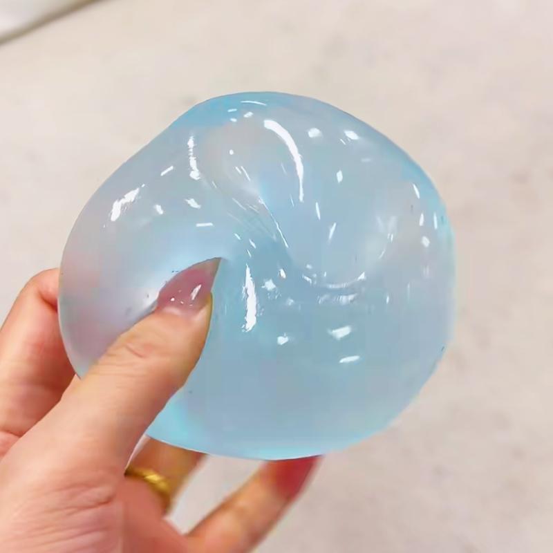 eine transluzente hellblaue gallertartige Fidget-Spielzeug-Stressball-Kugel aus TPR-Material, mit Kokosöl angereichert, zur Stresslinderung und Entspannung.