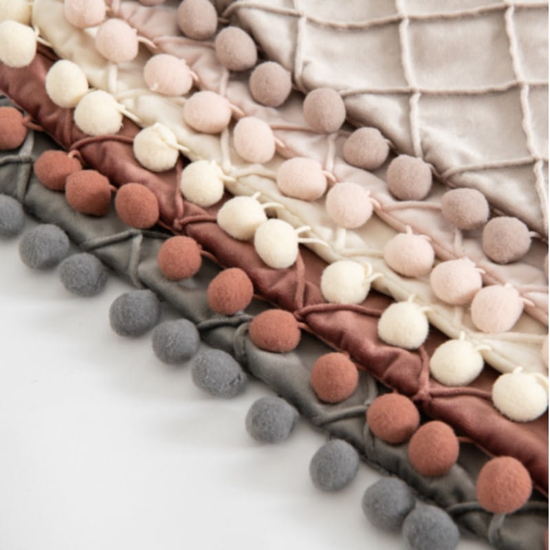 housse de coussin en velours gris avec une garniture à pompons texturée et douce, dans des tons terre atténués, cousue le long du bord pour des housses de coussin décoratives recevant des retours positifs