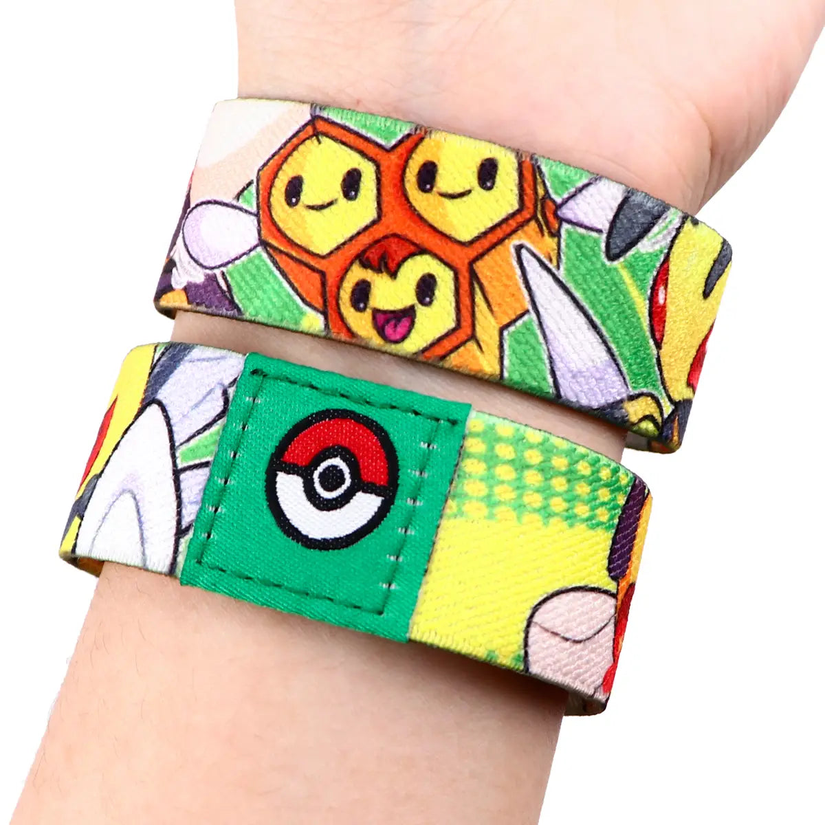 A person wearing two colorful elastic Pokémon-themed stretch wristband bracelets made of fabric.