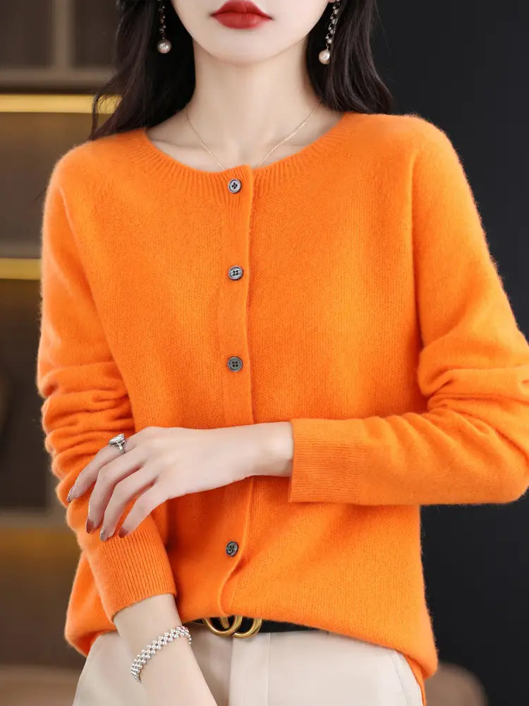 Vibrant orange merino wool cardigan for women featuring a round neckline long sleeves and button closure.