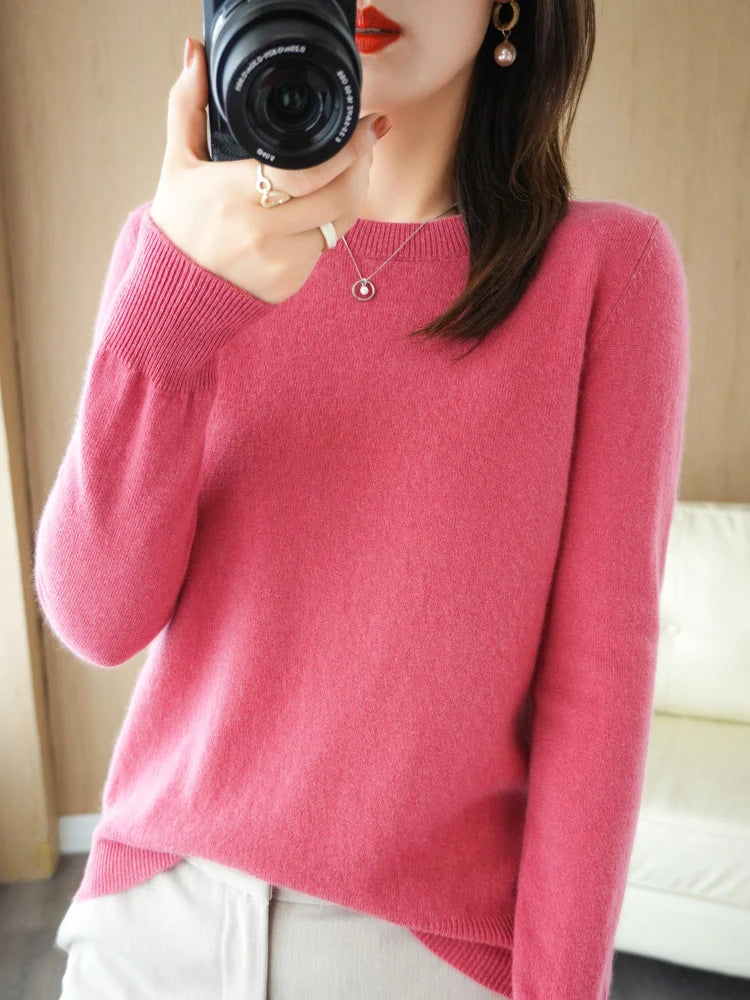 Ein weicher rosa Merino-Woll-Pullover für Damen im Casual-Stil mit langen Ärmeln sowie geripptem Halsausschnitt und Bündchen.