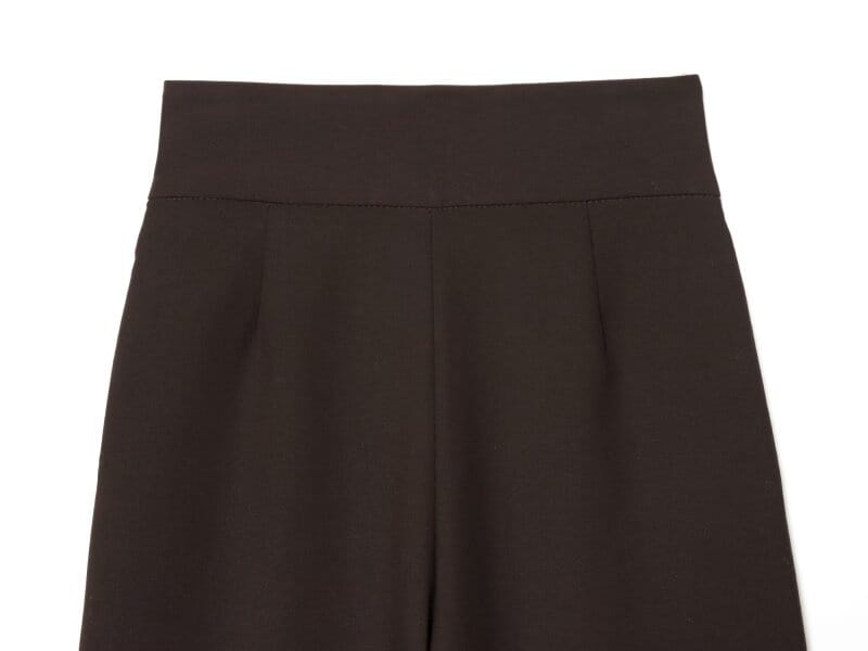 Pantalons noirs taille haute à jambes évasées en tissu lisse et structuré, avec des plis subtils.