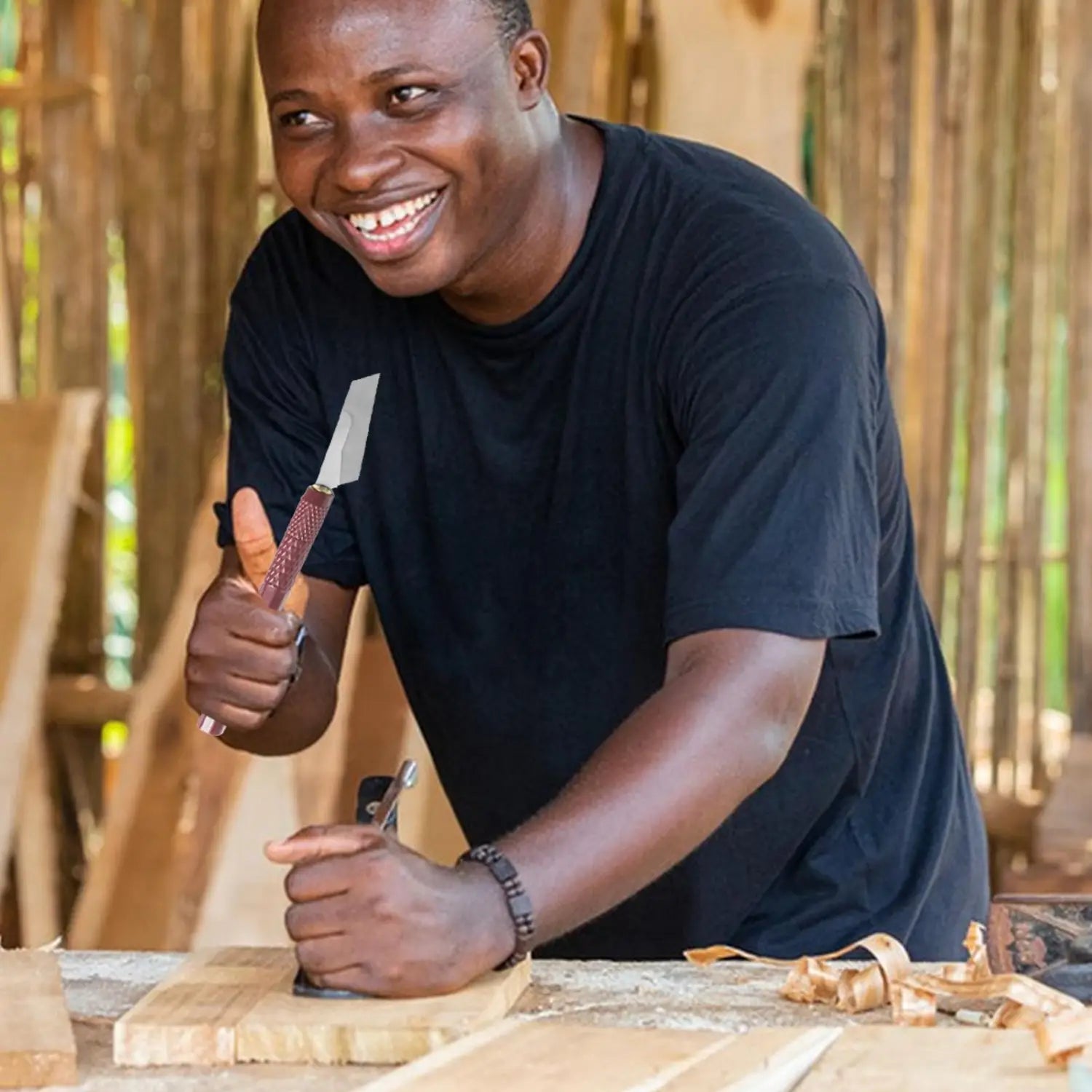 A man holds a model craft hand saw kit carving knife with a textured reddish-brown handle and a sharp metallic blade featuring four interchangeable blades.