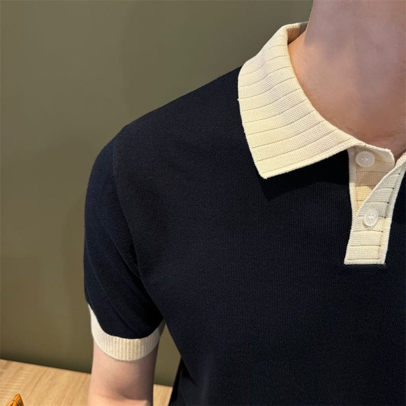 Camiseta tipo polo de punto con bloques de color en negro con cuello acanalado color crema y puños de las mangas, confeccionada en tejido de punto.