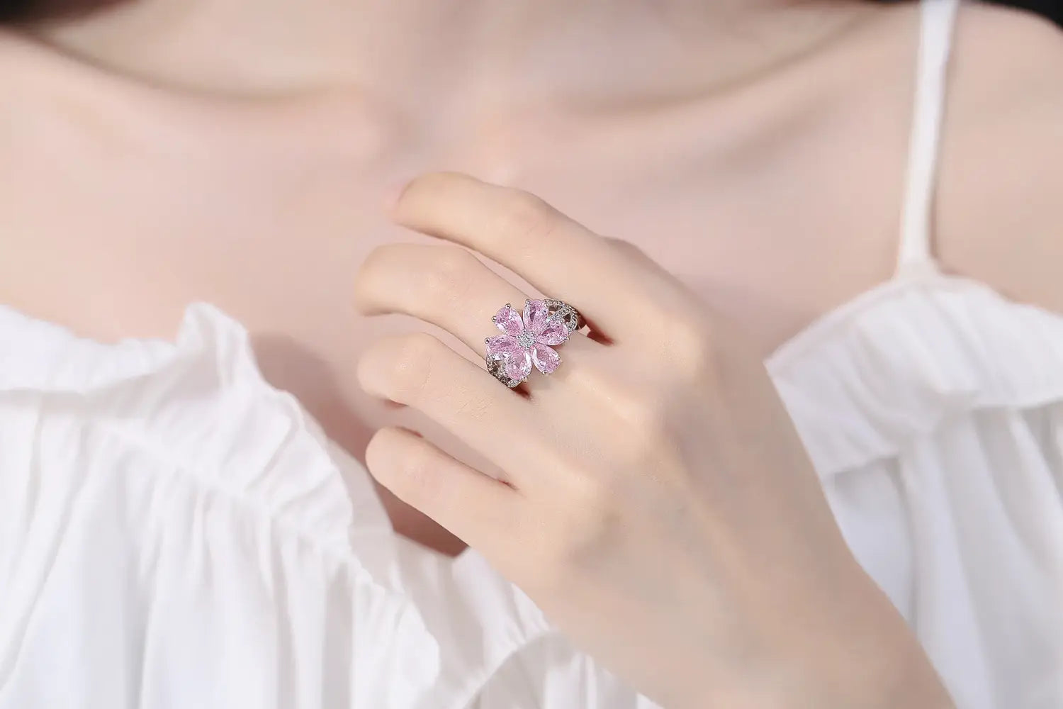 Ein zarter Ring in Form einer Blume aus Rosa und Silber, verziert mit funkelnden Edelsteinen, aus dem Schmuckset „Silver Pink Cherry Blossom“.