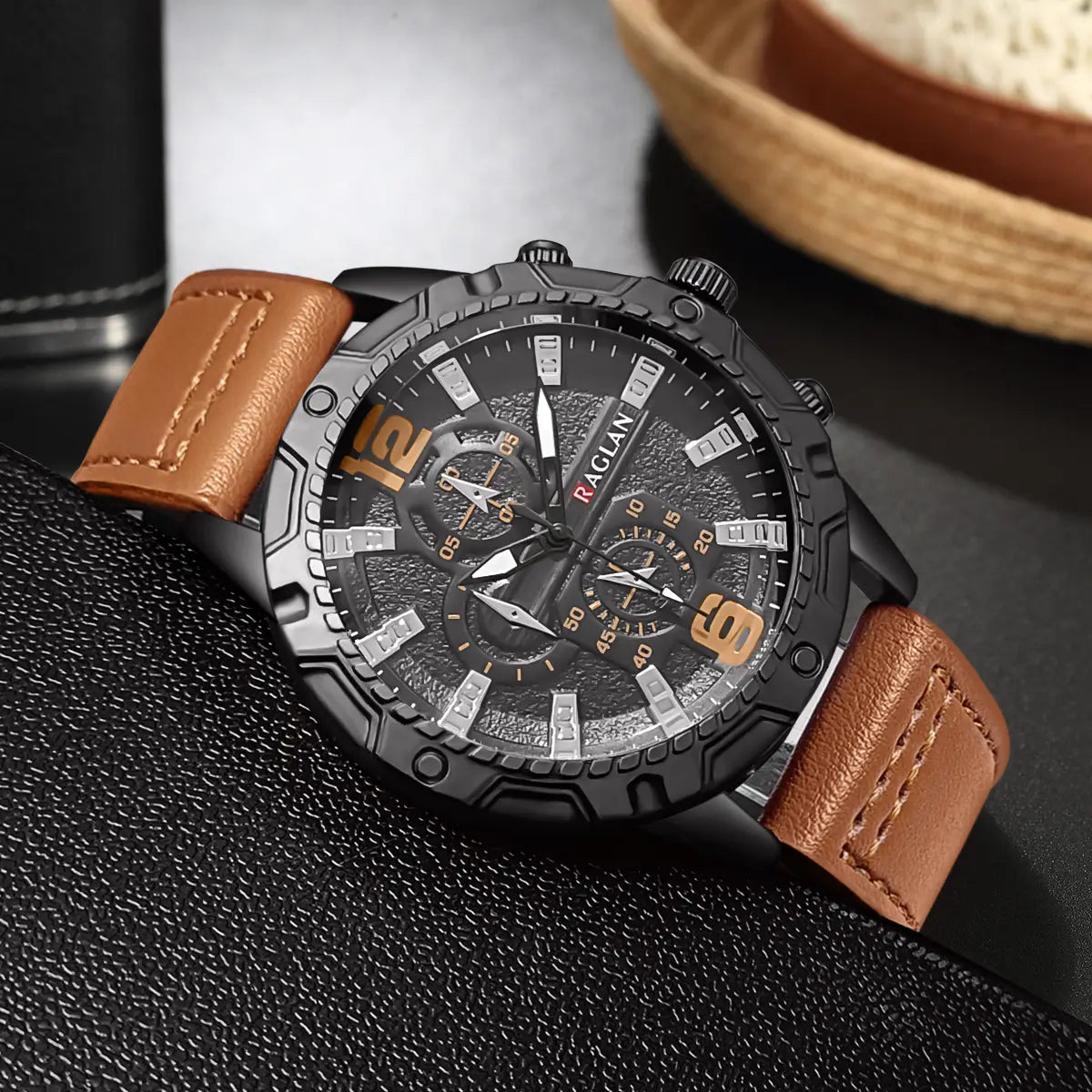 Montre à quartz pour homme avec chronographe, en cuir, avec boîtier raglan noir, bracelet en cuir tan et chiffres orange sur un cadran noir texturé.