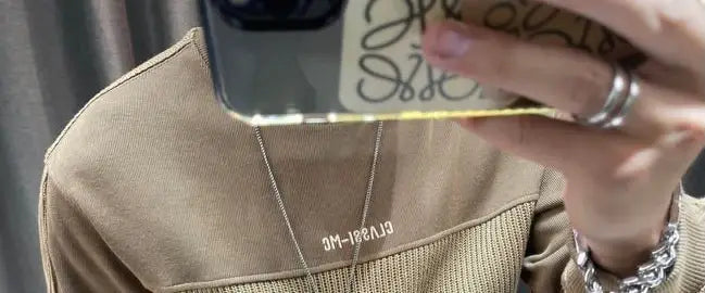Pull-over en maille à empiècement contrastant beige pour homme, manches longues, présentant un tissu en maille texturée et un logo brodé blanc discret sur la poitrine.