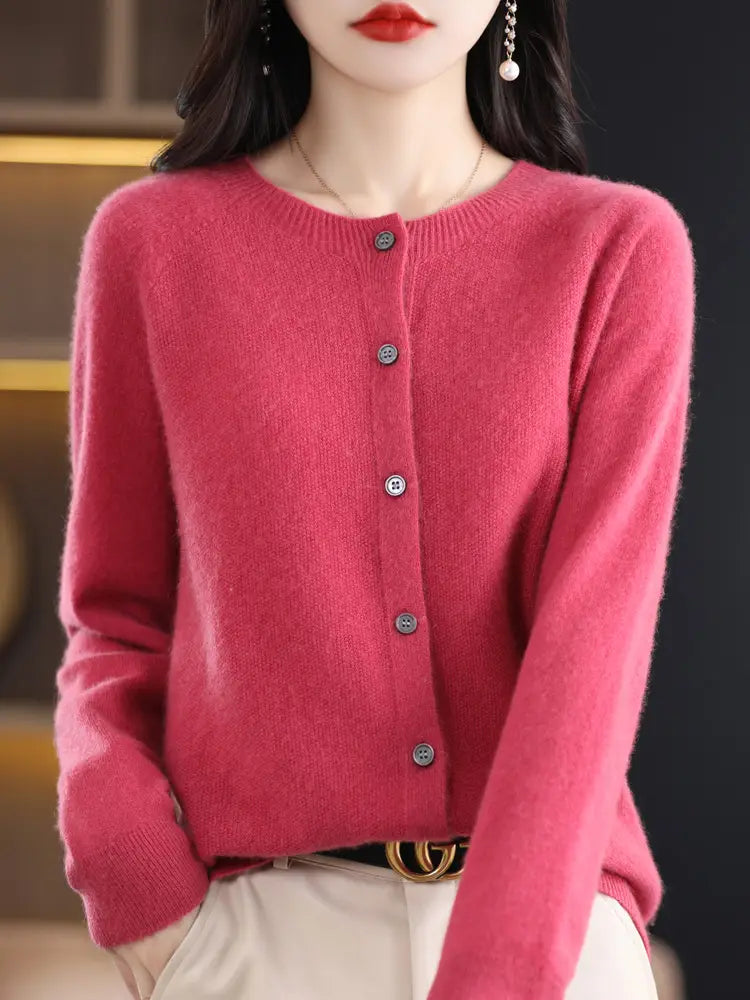 A soft vibrant pink merino wool cardigan for women featuring a round neckline and five matching metallic buttons down the front.