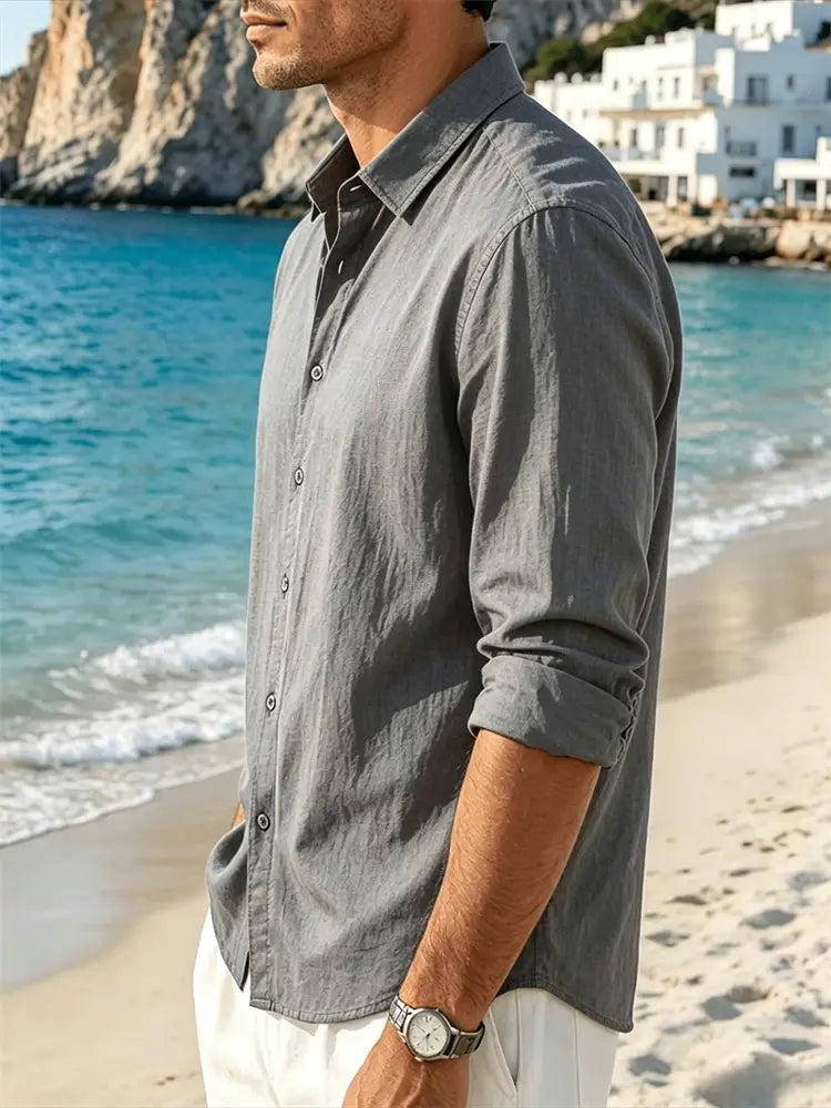 Un homme portant une chemise grise pour homme en coton et lin à manches longues, avec poignets retroussés et une texture discrète.