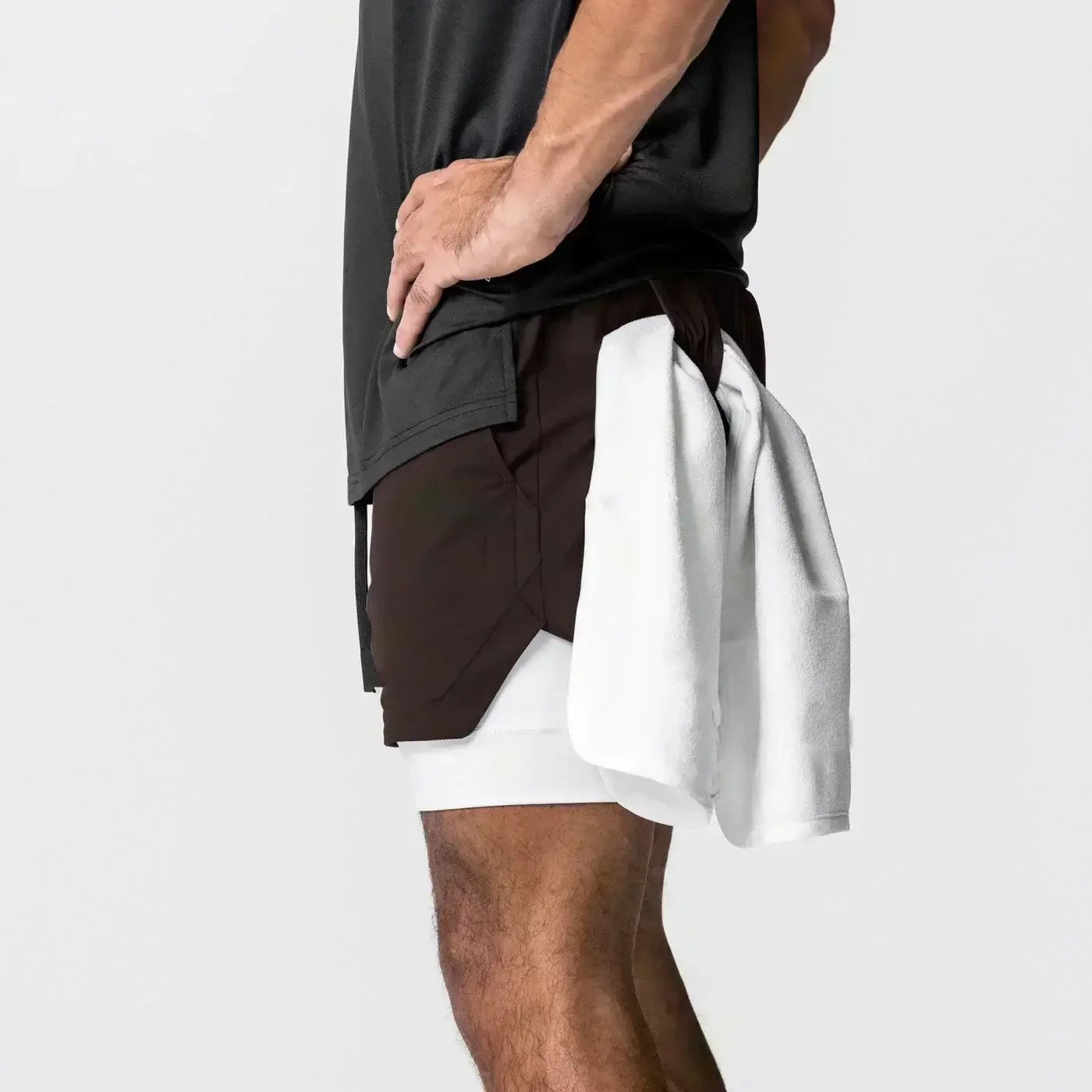 Hombres, pantalones cortos atléticos de dos capas negros y blancos para gimnasio con cintura elástica y trabilla para la toalla, diseñados para uso en entrenamientos.