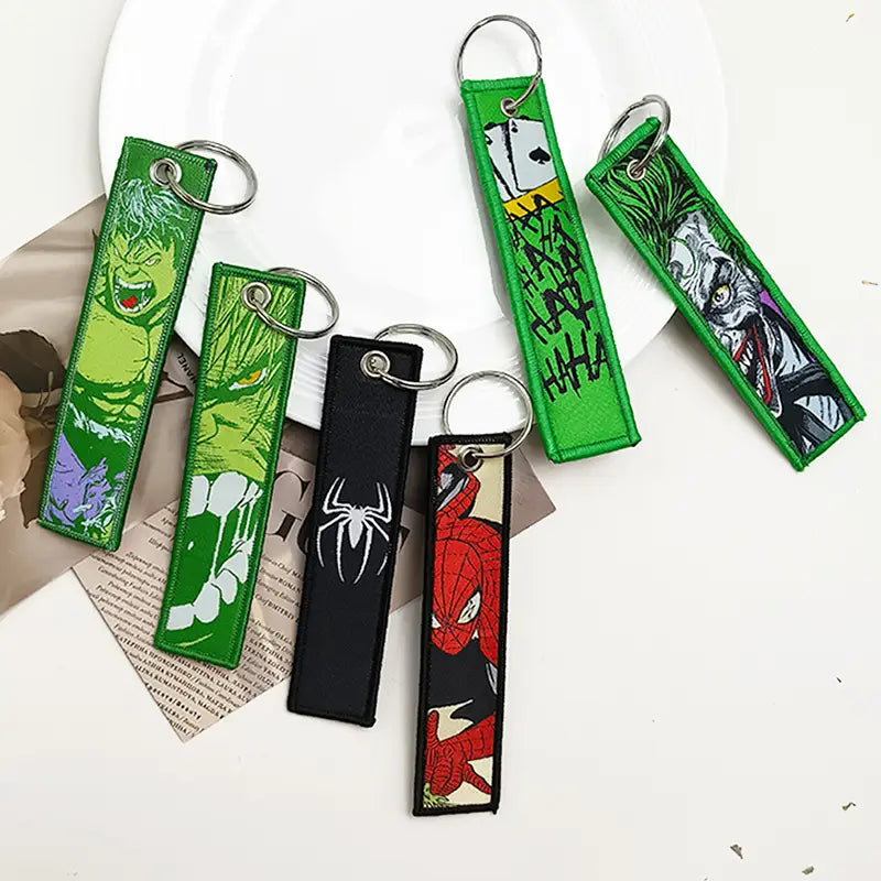 Superhero embroidered keychain set featuring green and black thread designs of the Hulk, Joker, Spider-Man, and Venom characters for anime key lanyard use.