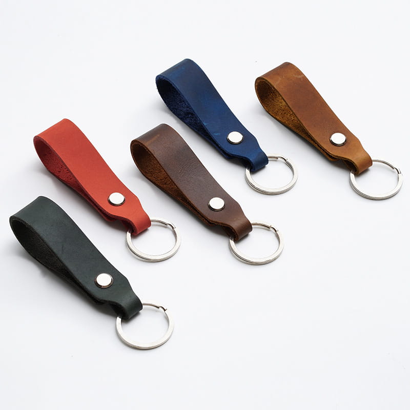Set of five genuine leather car keychains in red black brown navy blue and tan with silver-toned metal rings for lanyard key holding.
