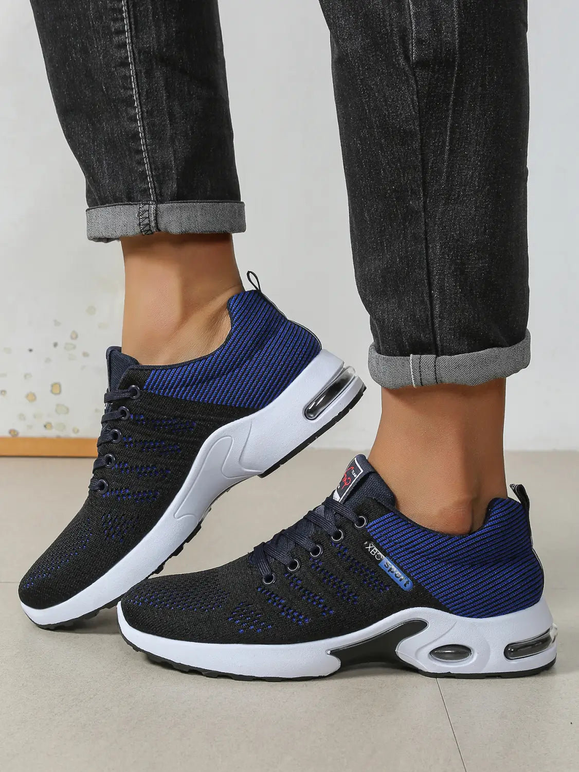 Baskets décontractées pour hommes en maille, chaussures de marche légères, bleues et noires, avec des semelles blanches et des unités de coussin d’air visibles.
