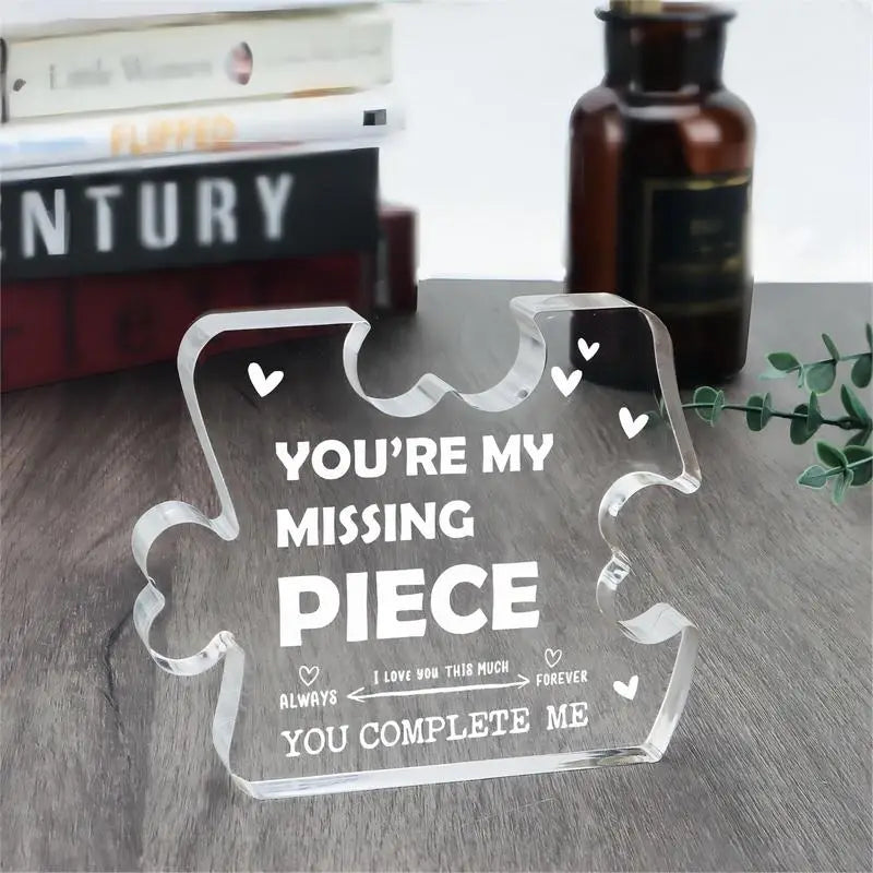 Plaque-souvenir en acrylique transparente représentant un couple de pièces de puzzle, avec un texte blanc gravé « vous êtes ma pièce manquante » et des cœurs décoratifs.