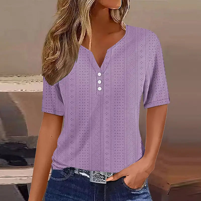 T-shirt boutonné pour femmes à encolure en V et manches courtes, de couleur lavande, avec trois boutons blancs et un motif ajouré sur l’ensemble du tissu.