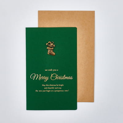 green christmas greeting card with gold foil lettering and a small golden stocking charm from a christmas greeting cards set with gold foil envelopes.
