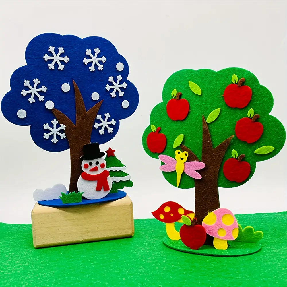 kit de manualidades estacionales de árbol de fieltro tipo diy que incluye un árbol de fieltro azul con recortes de copos de nieve blancos y un tronco marrón, presentado con una escena nevada que incluye un muñeco de nieve con un gorro de copa negro y una bufanda roja.