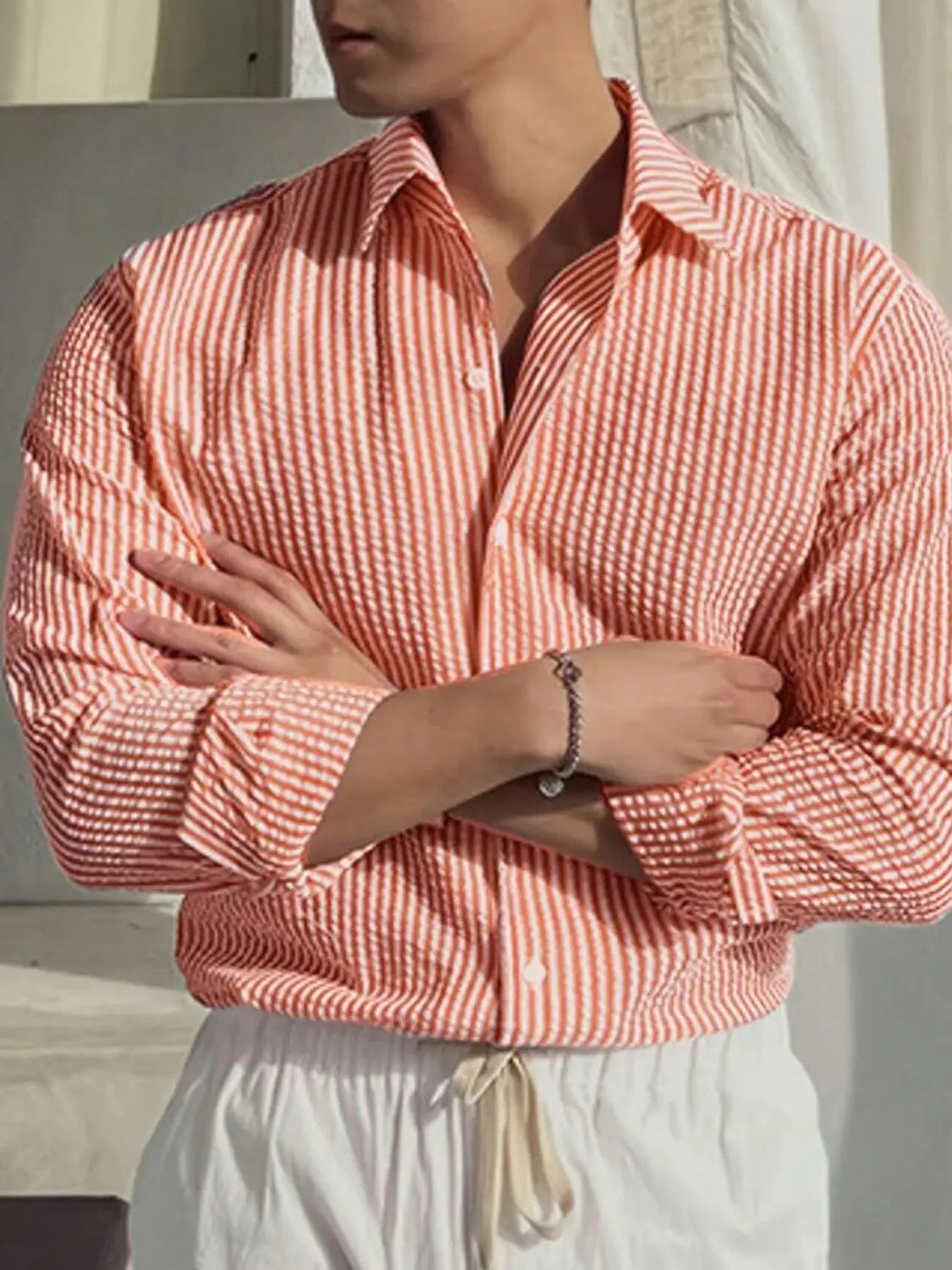 Chemise décontractée boutonnée manches longues à rayures verticales corail et blanc pour homme, avec un col classique.
