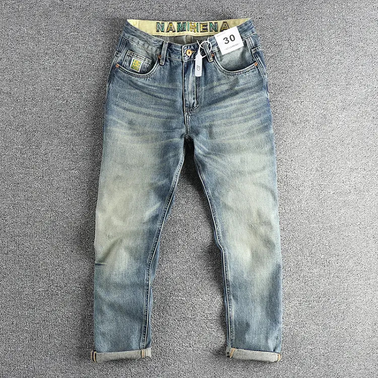 Jeans en denim ample à broder pour hommes en denim clair, avec un aspect délavé et vieilli et des revers retroussés.