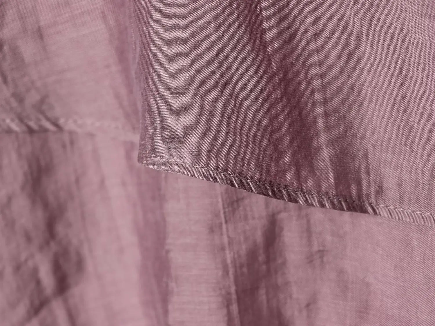 A brown chiffon flare sleeve blouse made of soft dusty rose-colored linen fabric with a subtle sheen and visible woven texture featuring a distinctive sleeve style.