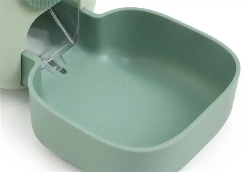 A sleek matte sage green automatic pet feeder made of high-quality plastic with food storage and a transparent plastic spout.