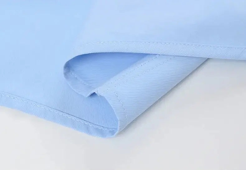 Light blue cotton fabric with neat matching stitching along the folded edge of a men long sleeve dress shirt anti wrinkle formal office white.