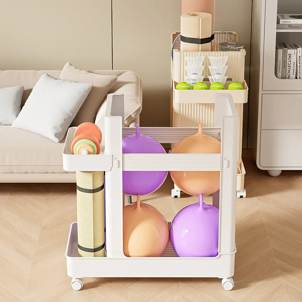 White plastic gym equipment organizer trolley with wheels and multiple compartments holding colorful exercise balls and rolled yoga mats.