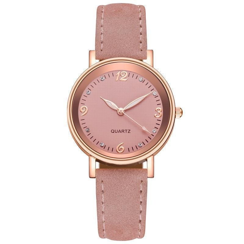 A delicate women quartz watch with a rose gold dial and matching blush pink suede leather band accented by crystal markers at 3 6 9 and 12 o’clock positions.