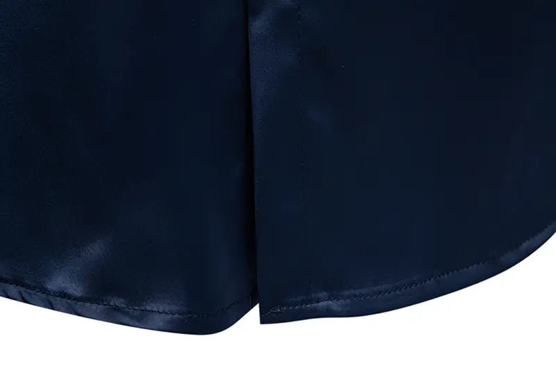 Navyblauer Satinstoff-Rock mit glatter, glänzender Oberfläche und sauberer Ziernähung entlang der Saumkante, kombiniert mit einem Herrenhemd mit goldfarbenem Besatz aus Satin.