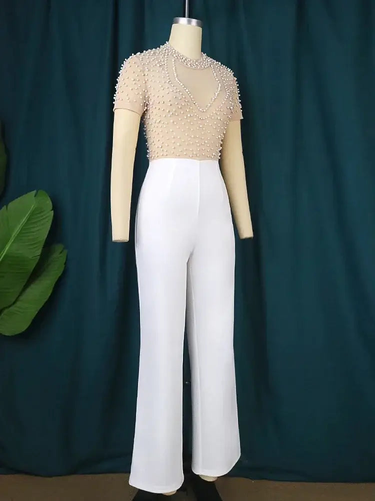beige beaded short sleeve top paired with high waisted white wide leg pants in an elegant party outfit