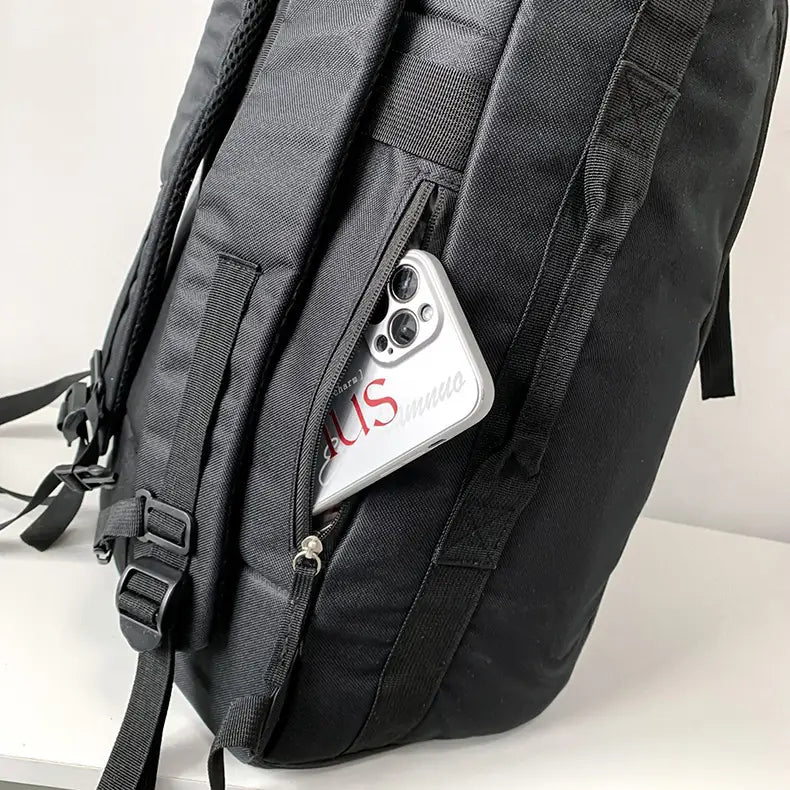 black textured waterproof gym backpack and travel duffel bag with a side zippered pocket holding a silver phone case.