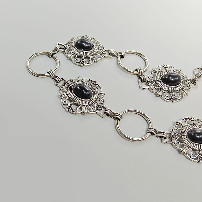 Ceinture de hanche en chaîne pour cosplay à tons argentés, comportant des maillons en filigrane floral ornés avec des pierres d’onyx noir ovales disposées dans chaque élément central, pour une ceinture de hanche de style gothique punk, accessoire pour femme.