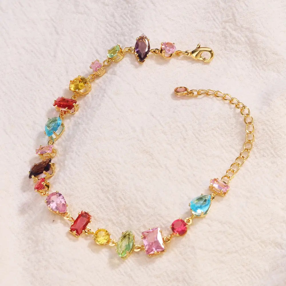 A vibrant gold-toned bracelet adorned with colorful faceted zircon crystals in pink blue green yellow and red is gold plated and designed for elegant wear.