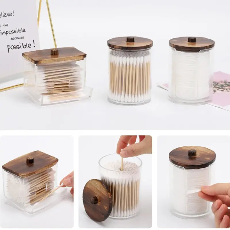 Clear glass acrylic q-tip and cotton ball storage jars with wooden lids designed to hold cotton swabs or q-tips.