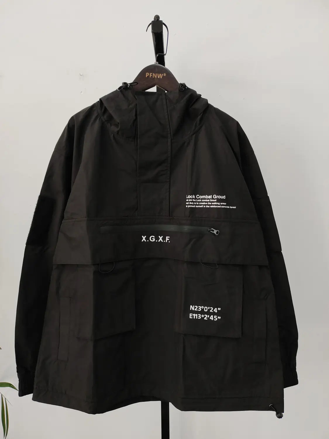 Veste imperméable à capuche tactique techwear noire x.g.x.f, présentée de dos, mettant en évidence sa matière durable et résistante à l’eau, conçue pour un usage en extérieur.