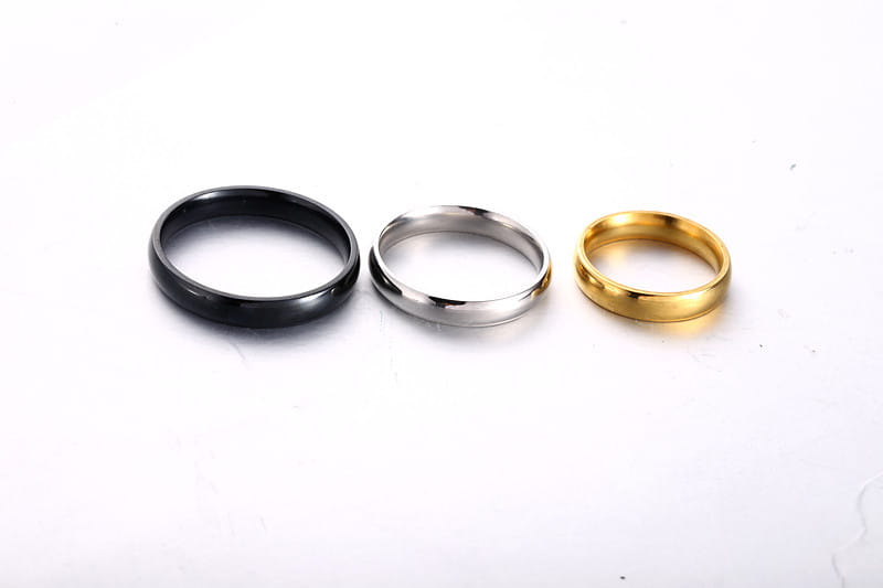 three sleek minimalist stainless steel wedding bands in black silver and rose gold finishes including a 6mm rose gold ring