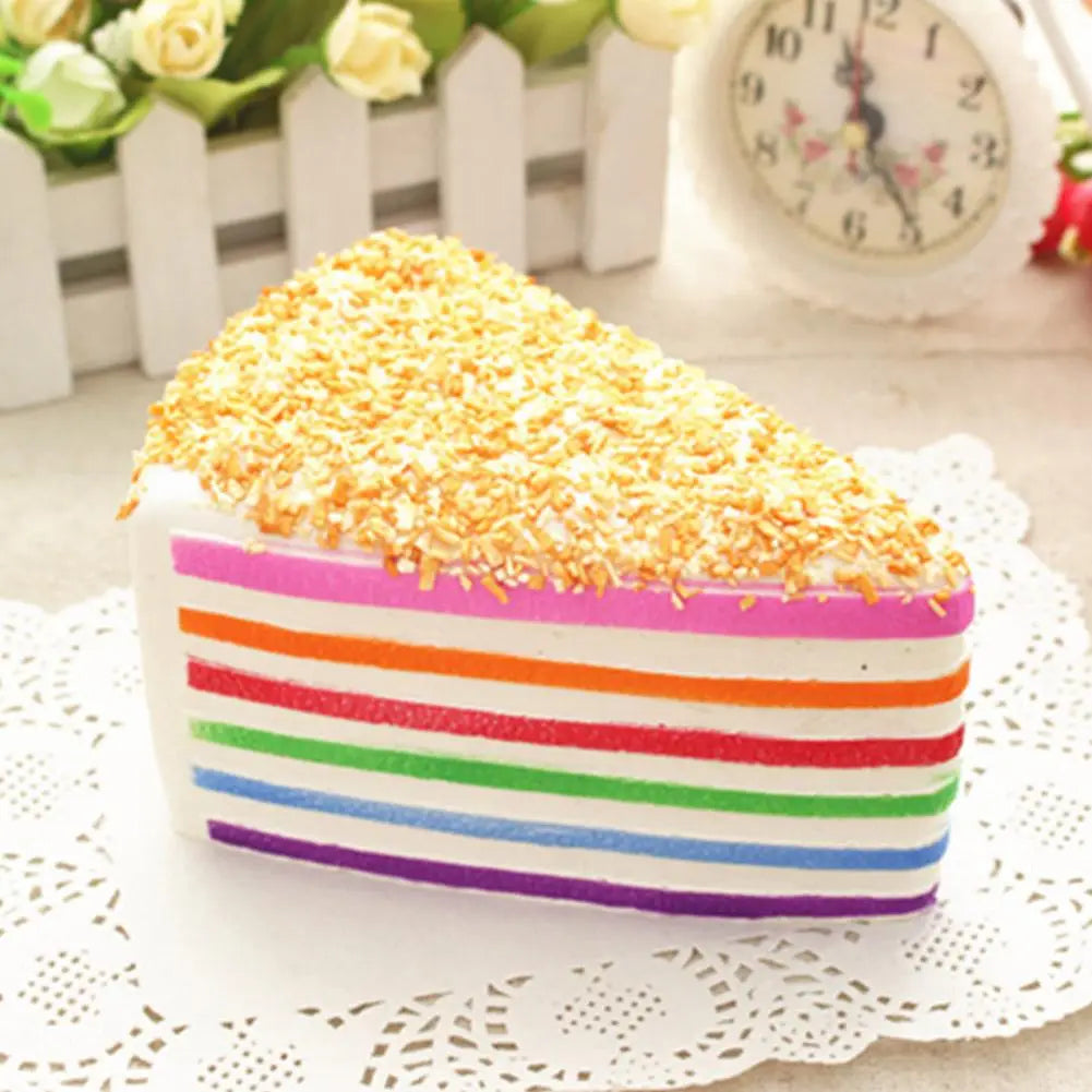 Jouet antistress à gâteau arc-en-ciel à rebond lent, fabriqué en silicone, en rayures arc-en-ciel, avec des flocons de coco dorés sur le dessus.