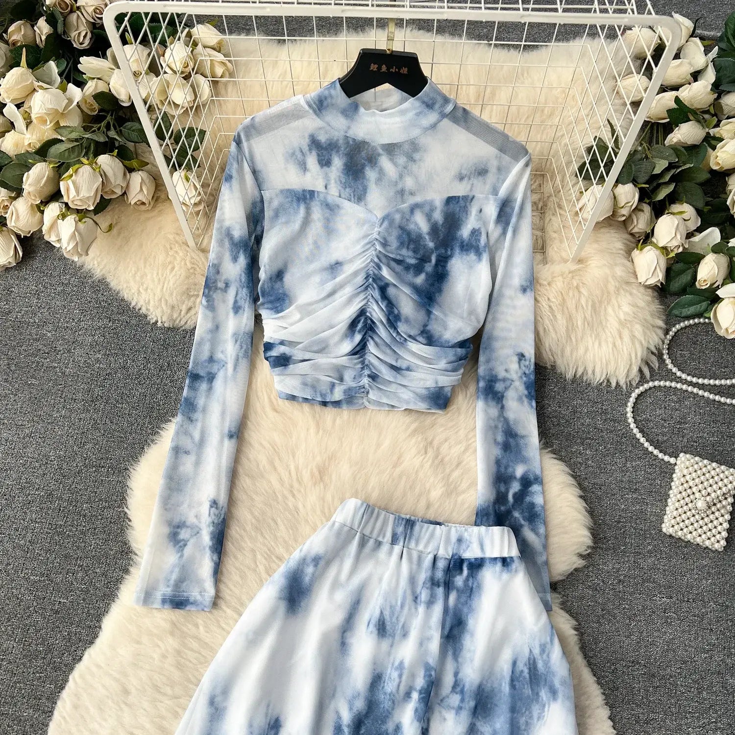 Blue and white tie-dye long-sleeved crop top with ruched front detail featured in a two piece mesh skirt set marble print with elastic closure type.