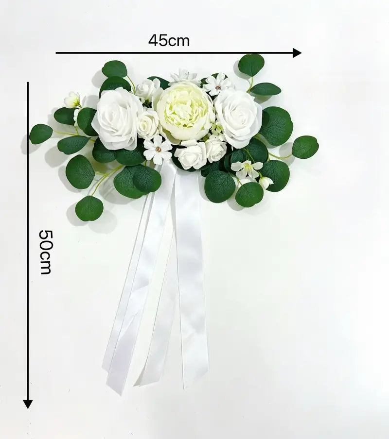 Corsage floral blanc élégant avec roses artificielles, eucalyptus et feuilles vertes, rehaussé d’un ruban en satin qui s’écoule, provenant du kit de décoration de voiture de mariage en rose artificielle et eucalyptus.