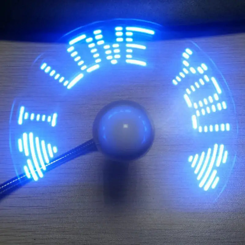 Un ventilador de reloj USB con LED azul, con diseño portátil y flexible, muestra la palabra "love" en luces blancas intensas en sus aspas en movimiento.