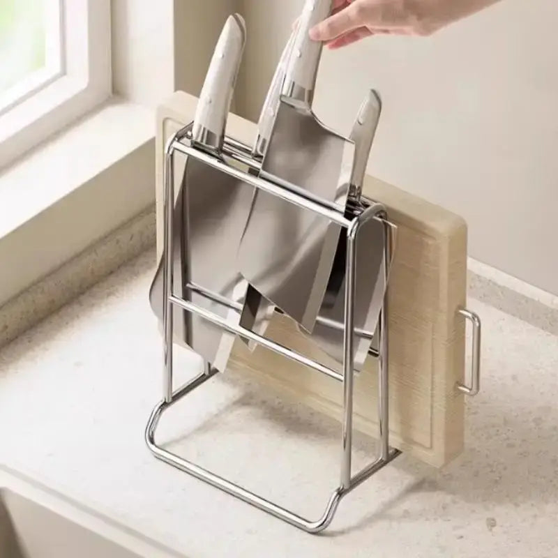 Organisateur de couteaux de cuisine en acier inoxydable au design minimaliste épuré, maintenant plusieurs couteaux et placé à côté d’une planche à découper en bois.