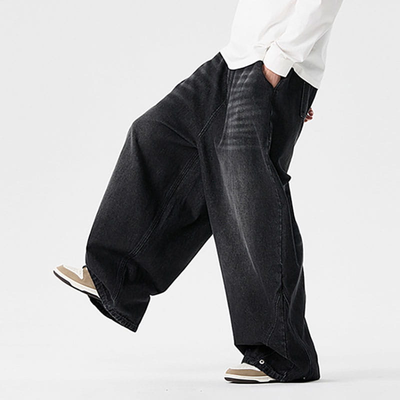 Des jeans japonais rétro à jambes larges pour hommes en grandes tailles en denim noir, avec une coupe légèrement fuselée et un léger effet délavé, présentant des détails subtils.