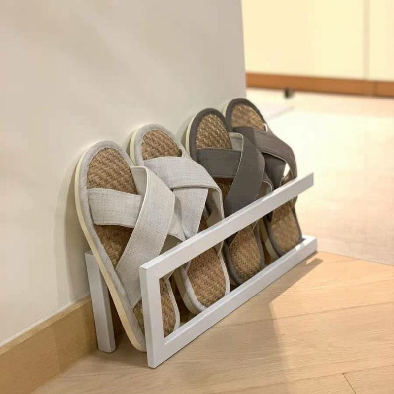 Weißes freistehendes Metall-Schuhregal aus Holz mit geflochtenen Espadrille-Sandalen, mit Stoffriemen für eine platzsparende Schuhorganisation.