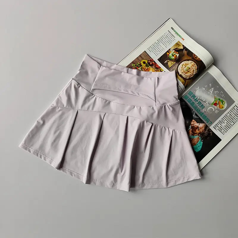 Ein hellgrauer Damen High-Waist-Sport-Tennisrock mit Falten, dezenten Ziernähte-Details und schnelltrocknendem Material.
